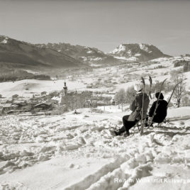 Zwei Skifahrerinnen bei der Rast mit Blick zum Kaisergebirge