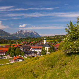 Reit im Winkl im Frühling mit Pfarrkirche und Blick zum Kaisergebirge