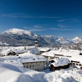 Pfarrkirche Reit im Winkl im Winter mit Kaisergebirge und Unterberg